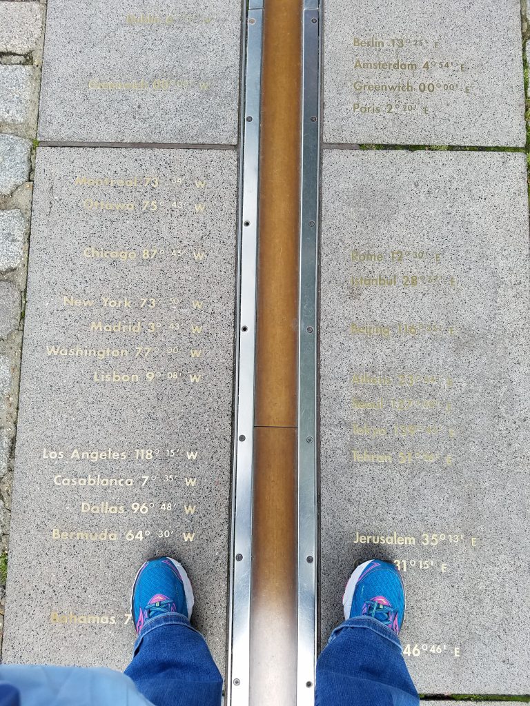 gold prime meridian with blue shoes on either side of line