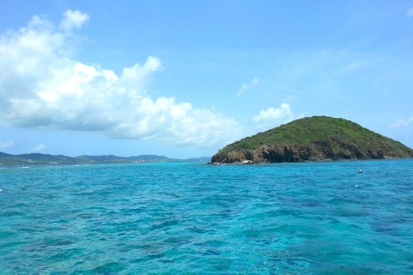 Buck Island, off the coast of St Croix, US Virgin Islands, in an aqua blue ocean with blue skies and white clouds above