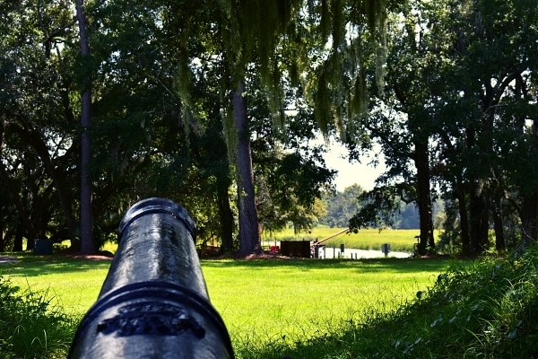 Black cannon overlooking the river from atop a green ridge