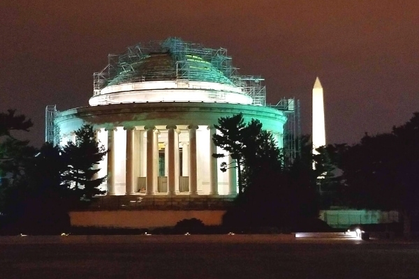 Jefferson and Washington Monuments at night, with scaffolding covering the Jefferson Memorial dome