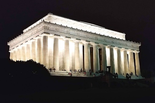 White marble Lincoln Memorial brilliantly lit up against a black night sky