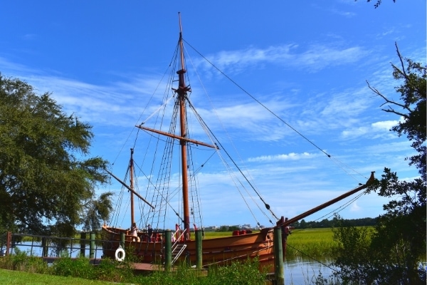 Replica 17th century light trading ship christened the Adventure, moored at a dock on the river