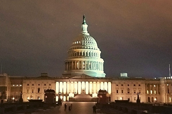 US Capitol building lit up against a cloudy night sky