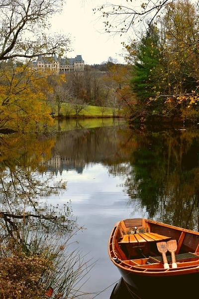 Rowboat on the Lagoon at the Biltmore Estate with fall trees and the Biltmore House reflected in the water