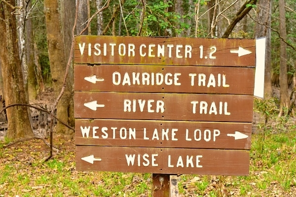 Congaree National Park brown trail guidepost with directional arrows for various trails and landmarks in the park