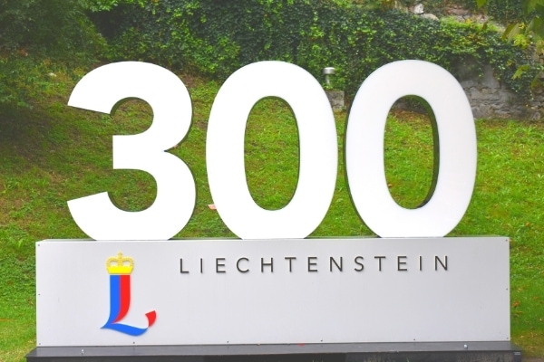 Large person-sized sign reading "300 Liechtenstein" with the Liechtenstein logo is set up to celebrate the country's anniversary