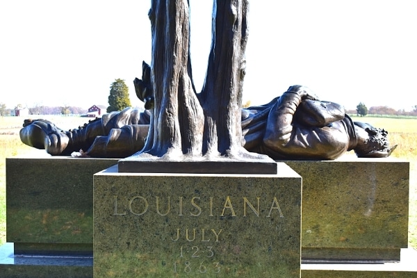 Stone and metal Louisiana Memorial at Gettysburg Battlefield where a fallen solider lies on his back looking out across the battlefield