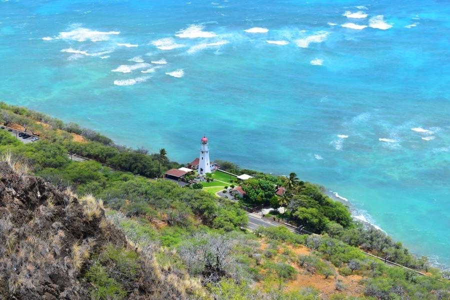 Lighthouse overlooking the various blue hues of the Pacific Ocean off the coast of Oahu