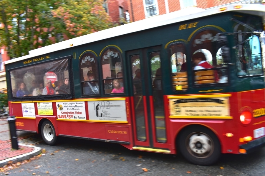 The Salem Trolley Tour zips by as passengers gaze out the windows as the guide narrates the history of Salem