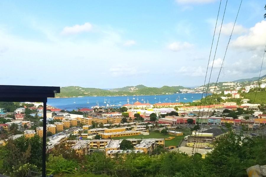 View of the blue Charlotte Amalie harbor with white sailboats from the residential populated hills above the water