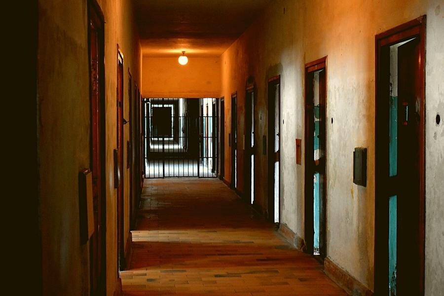 A dimly lit hallway in a former prison ward called The Bunker at Dachau Concentration Camp