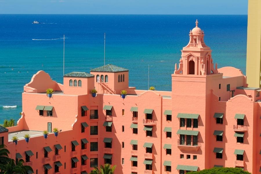 The pink Royal Hawaiian Hotel in Waikiki rises above the blue of the Pacific Ocean