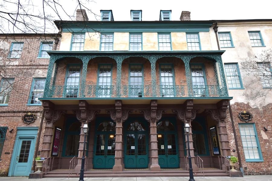 Historic Dock Street Theater with carved wooden posts and green wrought iron balcony