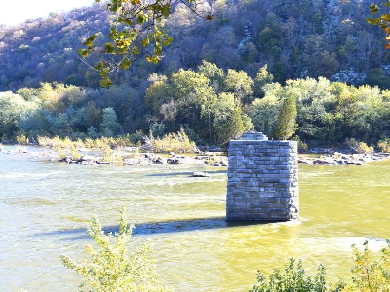 Remnants of stone bridge piers stand tall in the Shenandoah River as it flows past Harpers Ferry