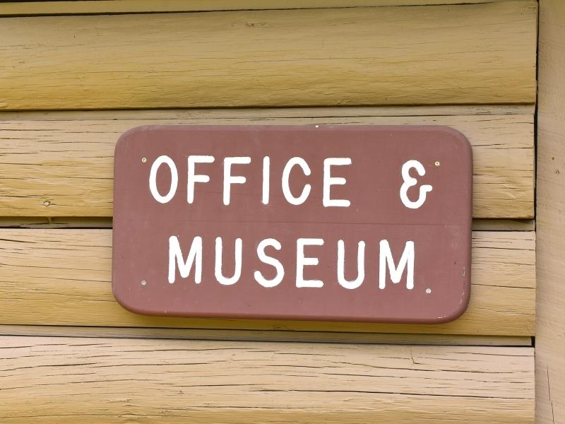 A brown and white sign on the side of a brown building for the Andrew Jackson State Park Office and Museum