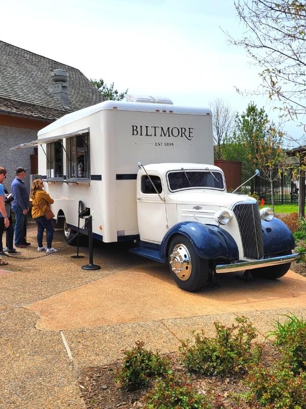 A white and blue vintage Biltmore dairy truck has been converted into the Smokehouse Food Truck in Antler Hill Village, serving hungry patrons