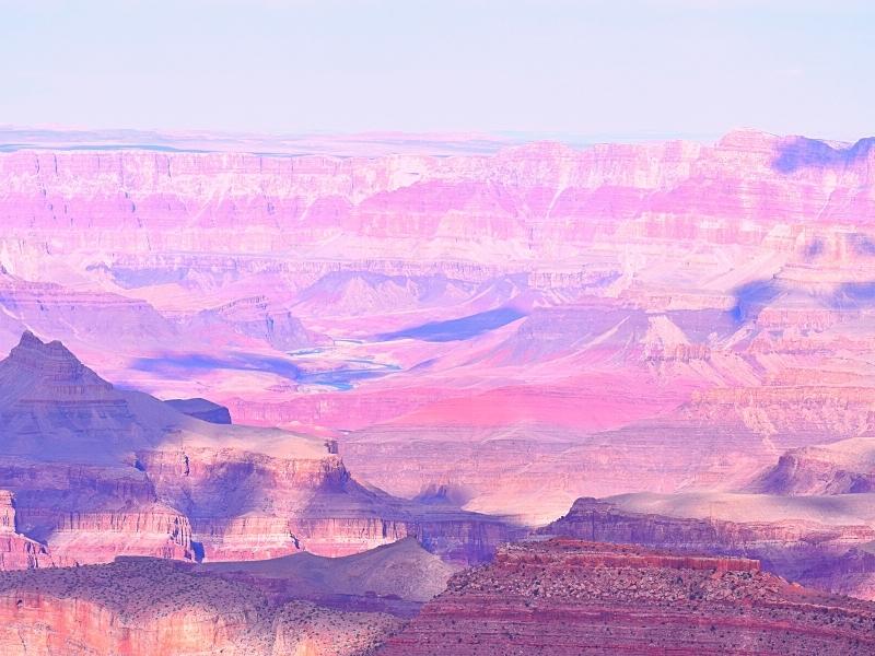 The many rock layers of the Grand Canyon glow pink in the late afternoon light