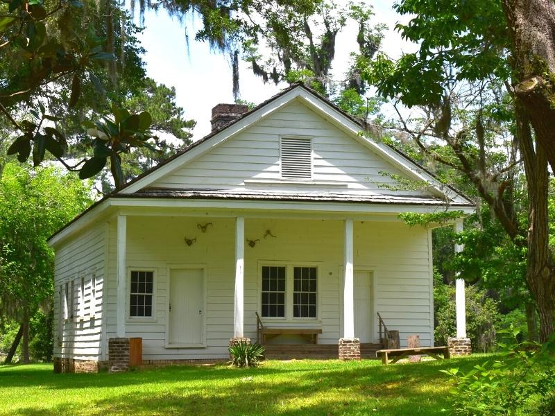 A single story white building with a covered porch served as the kitchen building for Hampton Plantation