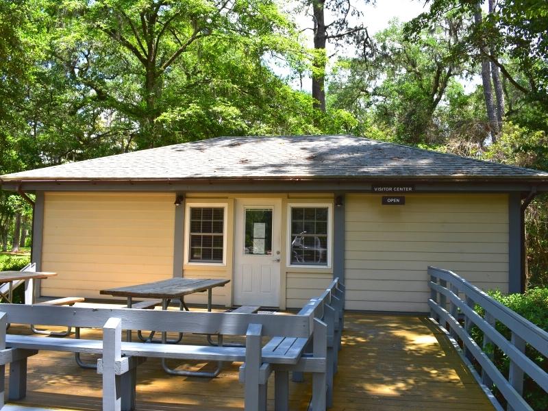A simple tan and gray building with picnic tables out front serves as the Hampton Plantation State Historic Site visitor center and gift shop