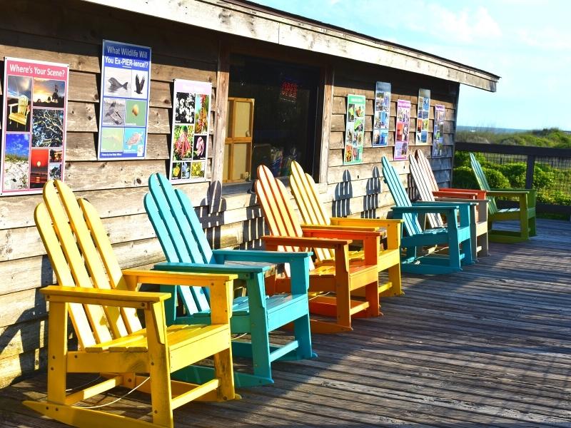 Colorful teal and yellow adirondack chairs at the fishing pier gift shop in Myrtle Beach State Park