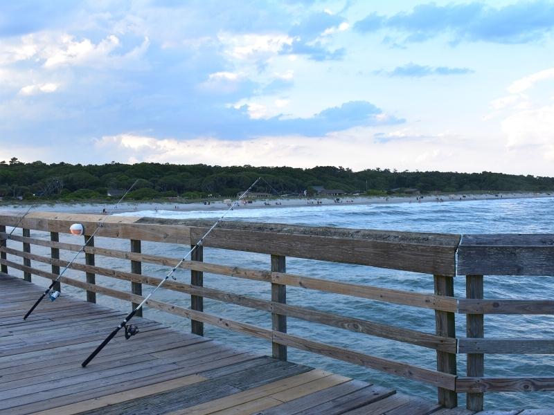 Fishing rods lean against the fishing pier rail at Myrtle Beach State Park