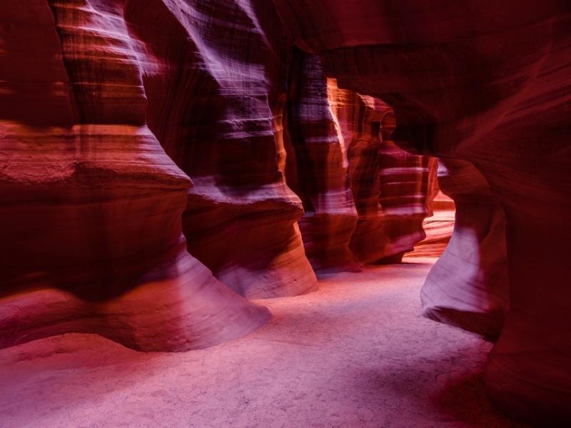 Wide sandy bottom of Lower Antelope Canyon is mostly in shade due to the narrow opening at the top