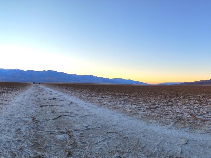 The salt flats of Badwater Basin stretch out to the moutains, gently illuminated with a golden tinge just after sunset.