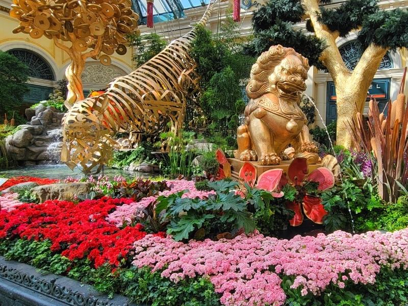 The Bellagio Conservatory decorated with gold statues and red and pink flowers for Chinese New Year