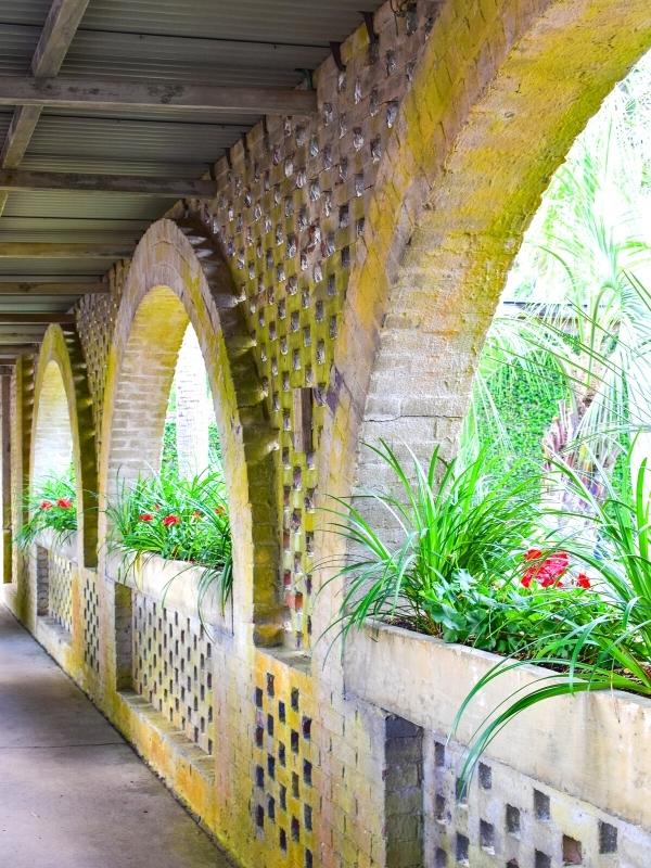 Brick archways glow yellow as the sun sets, making the flower boxes pop green at Atalaya Castle