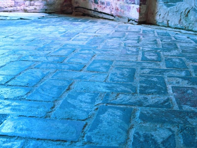 Floor bricks laid in a herringbone pattern with distressed swirls at Atalaya Castle in Huntington Beach State Park