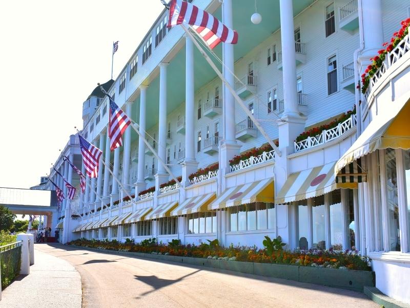 The multi-story columned front entry to The Grand Hotel on Mackinac Island lined with American flags
