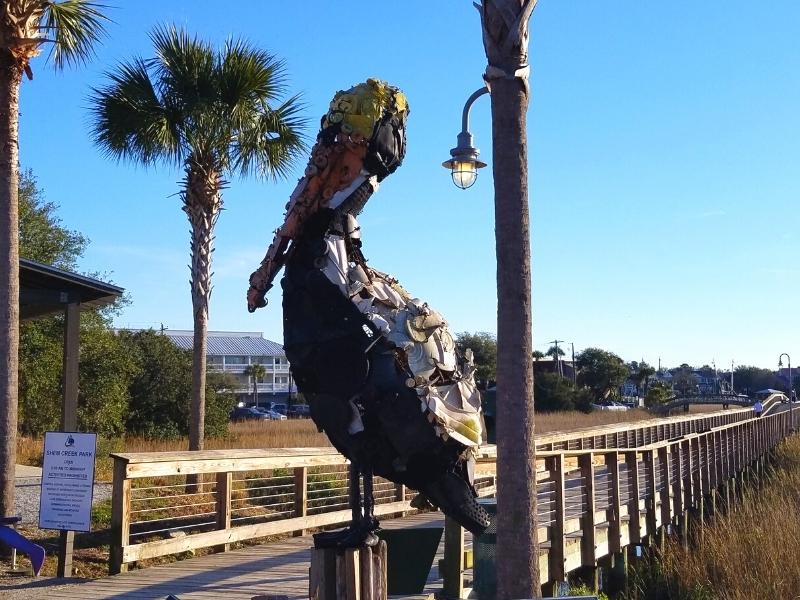 A pelican made of plastics saved from the ocean stands at the boardwalk entrance to Shem Creek park in Mount Pleasant, SC