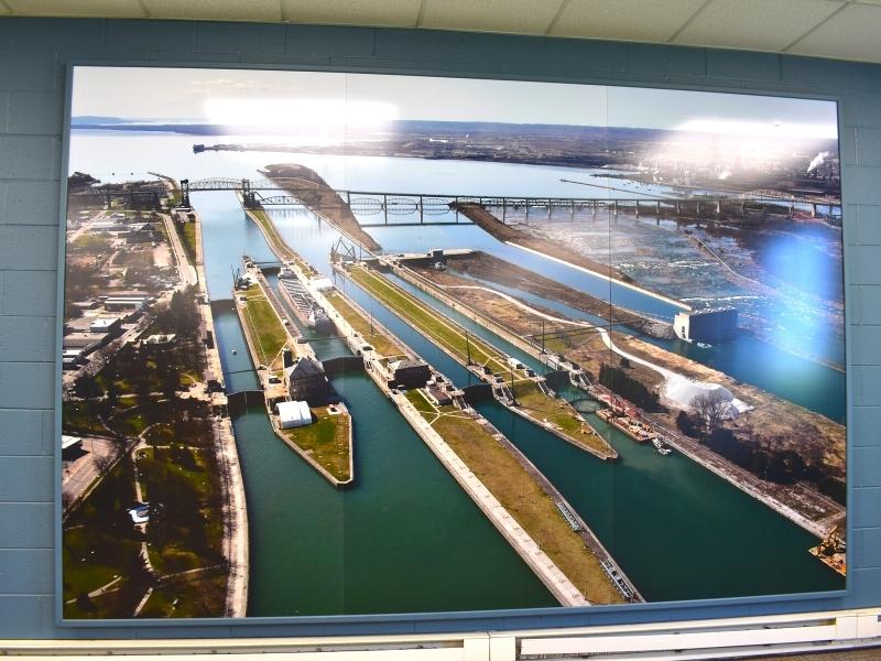 An aerial view photo of the Soo Locks on the wall of the Visitor Center