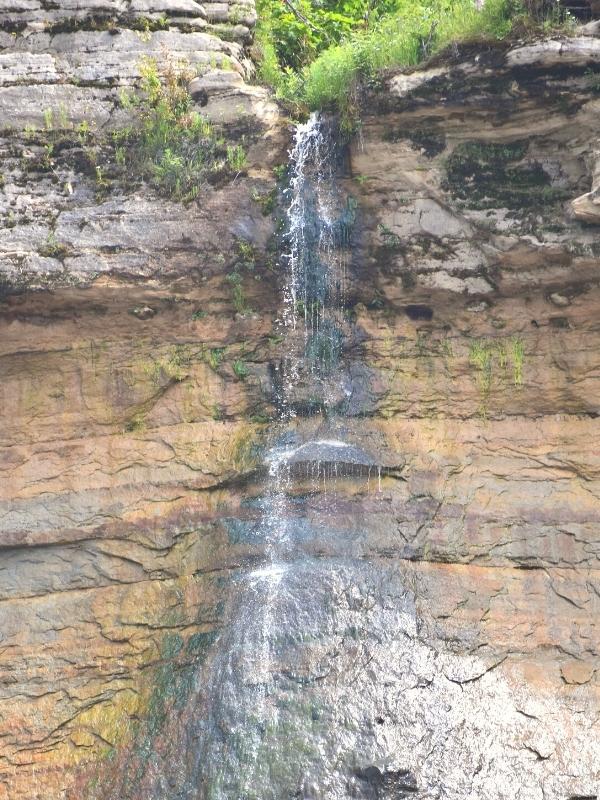 Bridal Veil Falls, a tiny trickle of water falls off the Pictured Rocks cliffs, staining them black