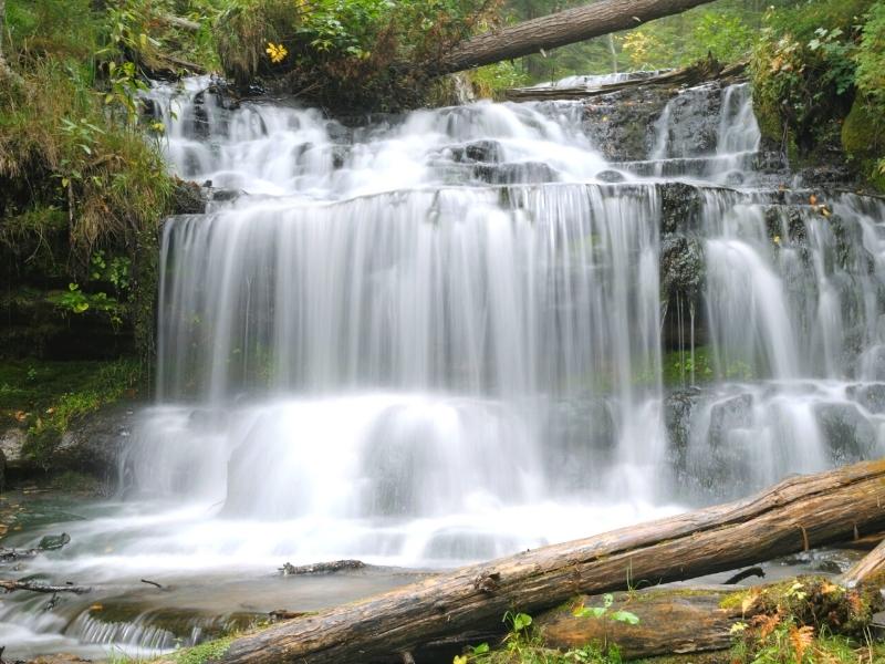 Close up long exposure photo of Wagner Falls falling over rock ledges near Pictured Rocks