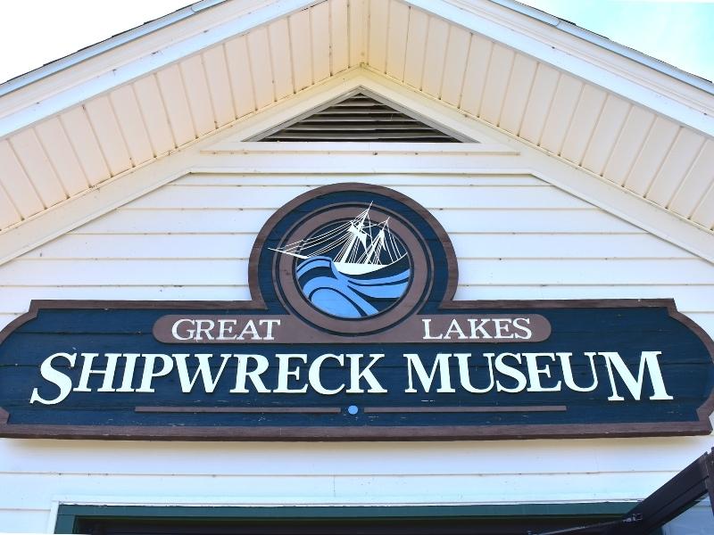Blue sign for the Great Lakes Shipwreck Museum on the white building