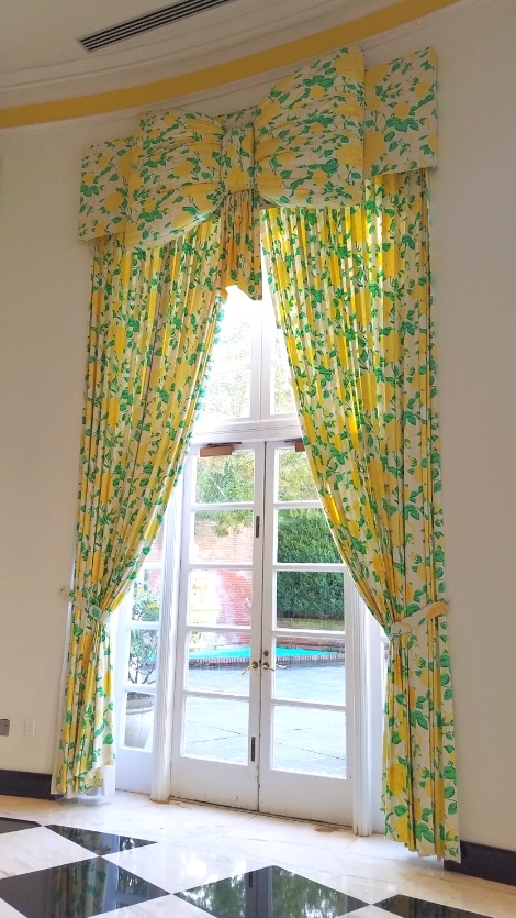 A doorway with lemon yellow floral curtains and a giant bow across the top at the Greenbrier