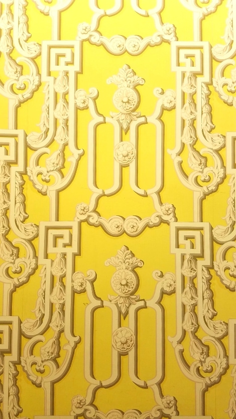Yellow wallpaper with a disorienting ornate cream pattern, meant to make people uncomfortable to hide the entrance to the Greenbrier Bunker