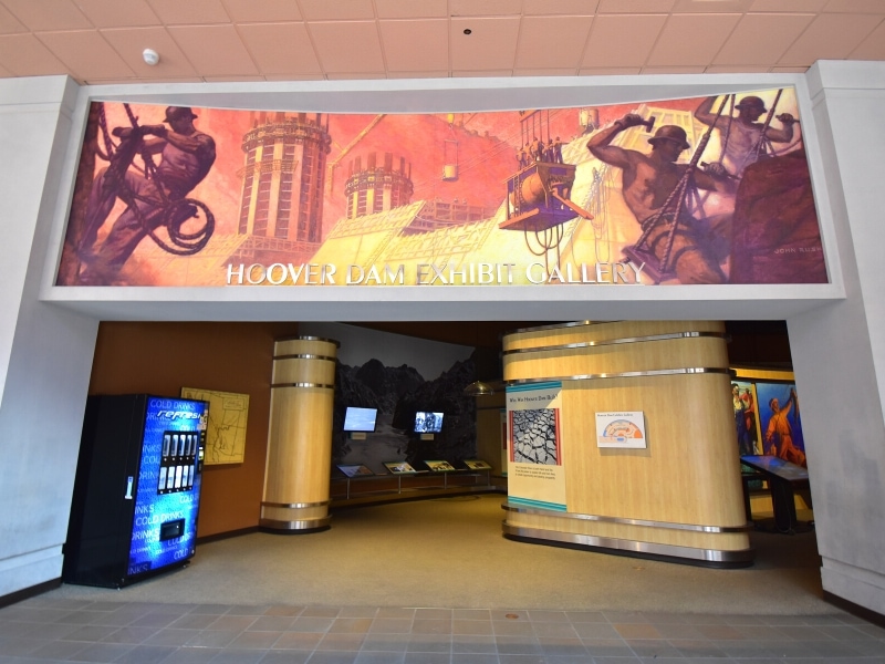 The front entrance to the Hoover Dam Exhibit Gallery at the Visitor Center features a large Art Deco-esque mural of workers building the Hoover Dam.