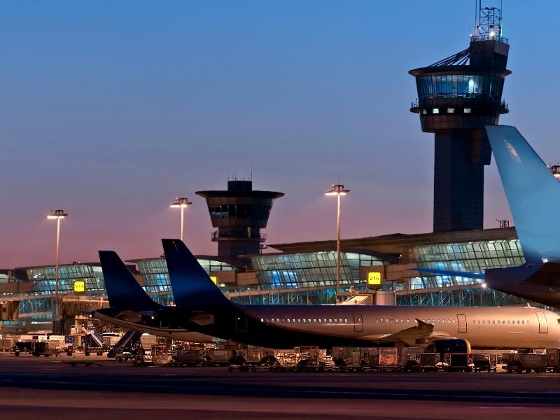 Planes sit at the gate at the Seattle Airport as the sun sets and the lights come on.