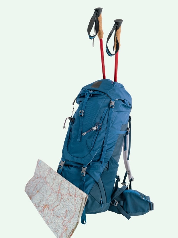 Blue hiking day pack with a map and red hiking poles stick out of the top