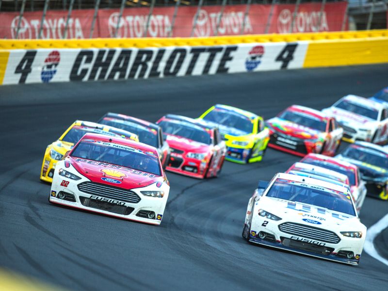 Cars in formation make their way around a turn at Charlotte Motor Speedway