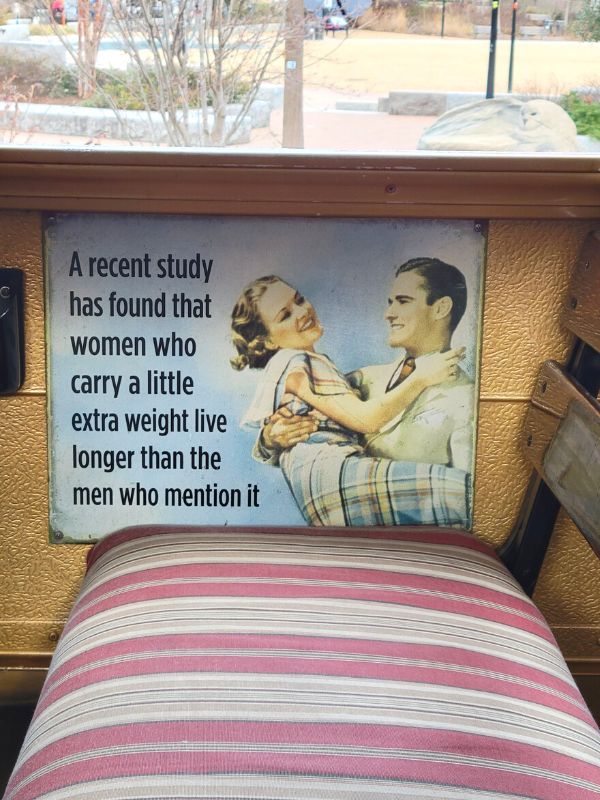 A humorous sign on The Funny Bus says, "A recent study has found that women who carry a little extra weight live longer than the men who mention it."