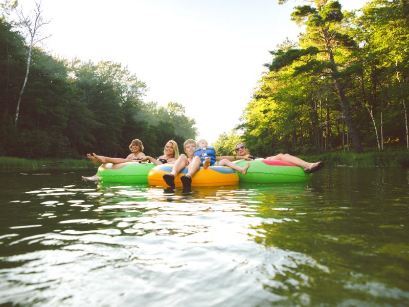 A group of 4 river tubers have tied their tubes together to float down the river as a group