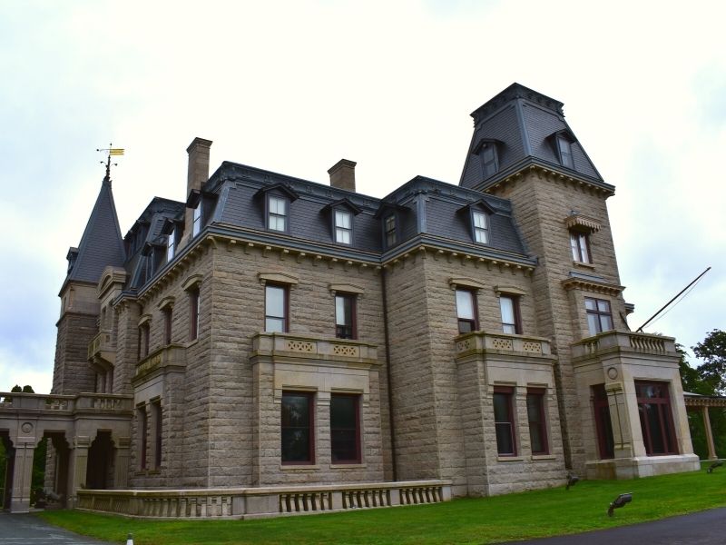 The stone siding and dark roof of Chateau sur Mer in Newport, Rhode Island