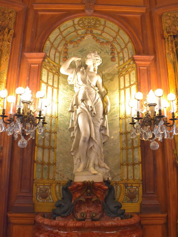 A stone statue in a marble decorated nook inside The Elms mansion in Newport