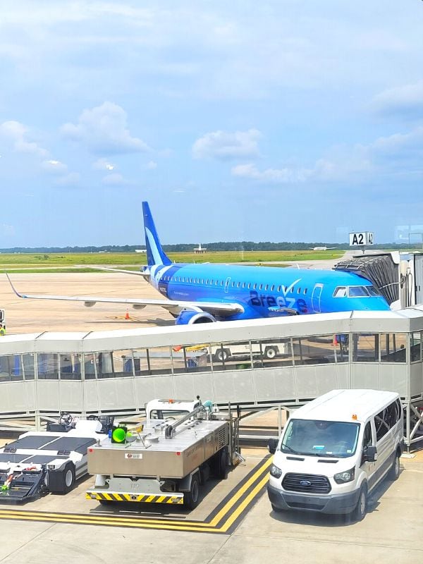 A blue Breeze Airways plane at the gate in Charleston, SC